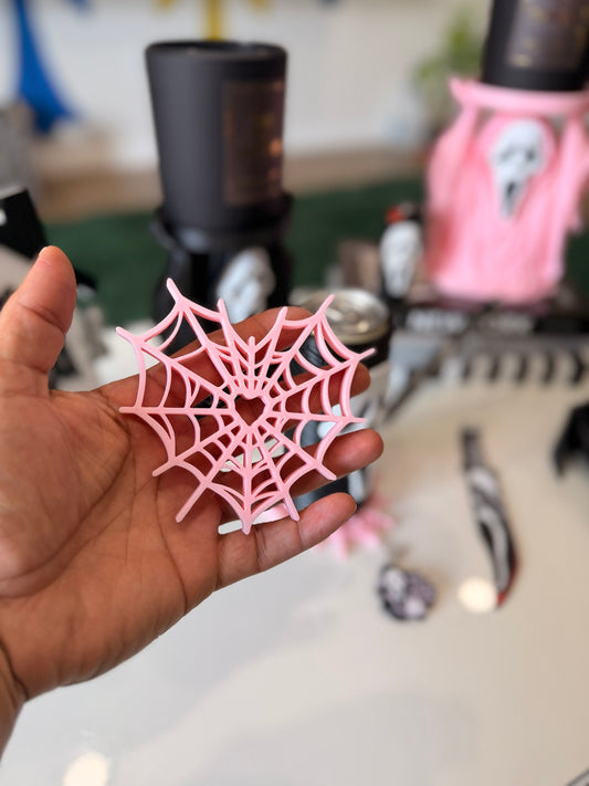 Pink heart spiderweb coaster held in hand